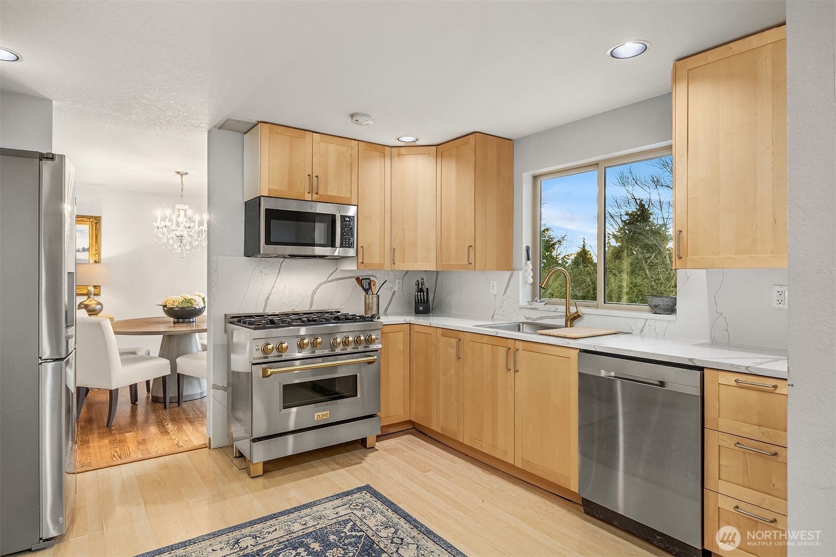 The chef's kitchen boasts this lovely gas range with brushed gold hardware.