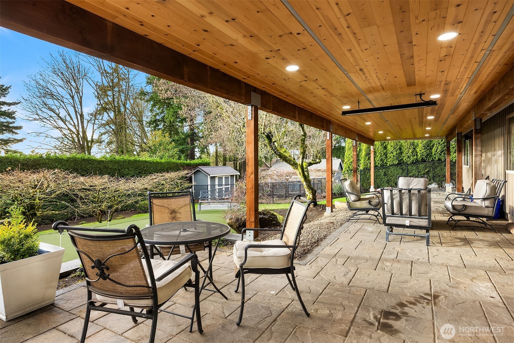 This fantastic stone patio enjoys a beautiful wood ceiling with lights and heaters for year round enjoyment.