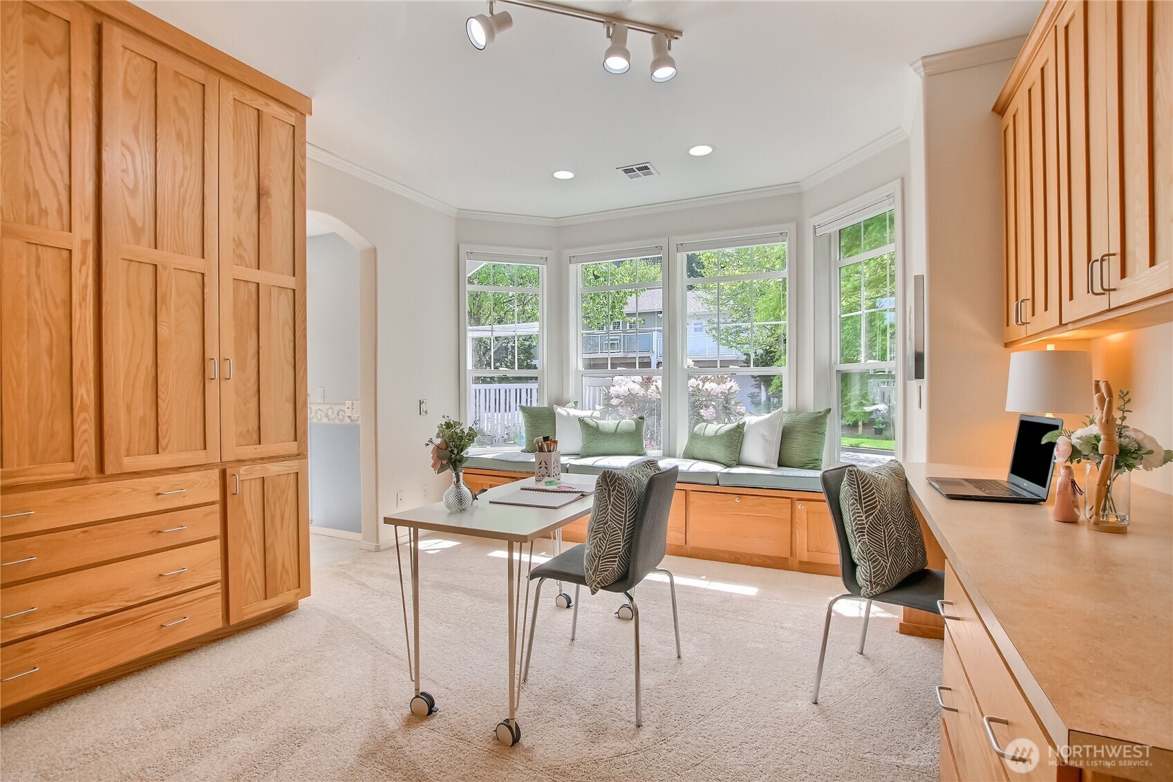 Primary suite with custom cabinets and bay window has plenty of storage for the crafter, extensive home office, quilting projects, artist, or a simply lovely bedroom.
