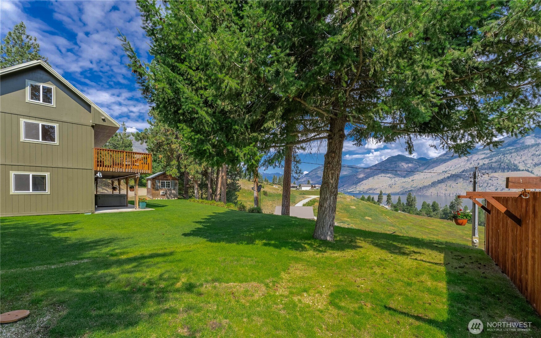Exterior view of grassy landscaped yard & mature shade trees.