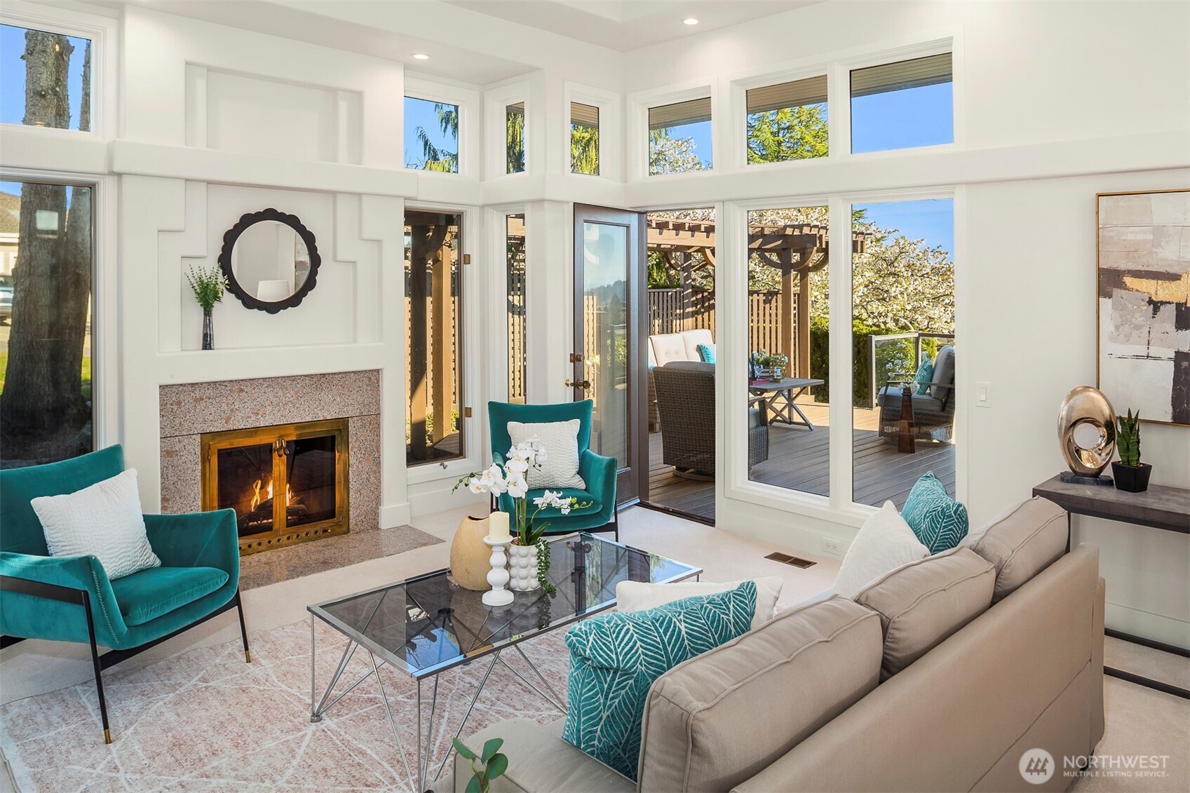 A gracious formal living room, hearth glowing softly, where fireside warmth spills onto the deck and sunlight lingers like a quiet invitation.