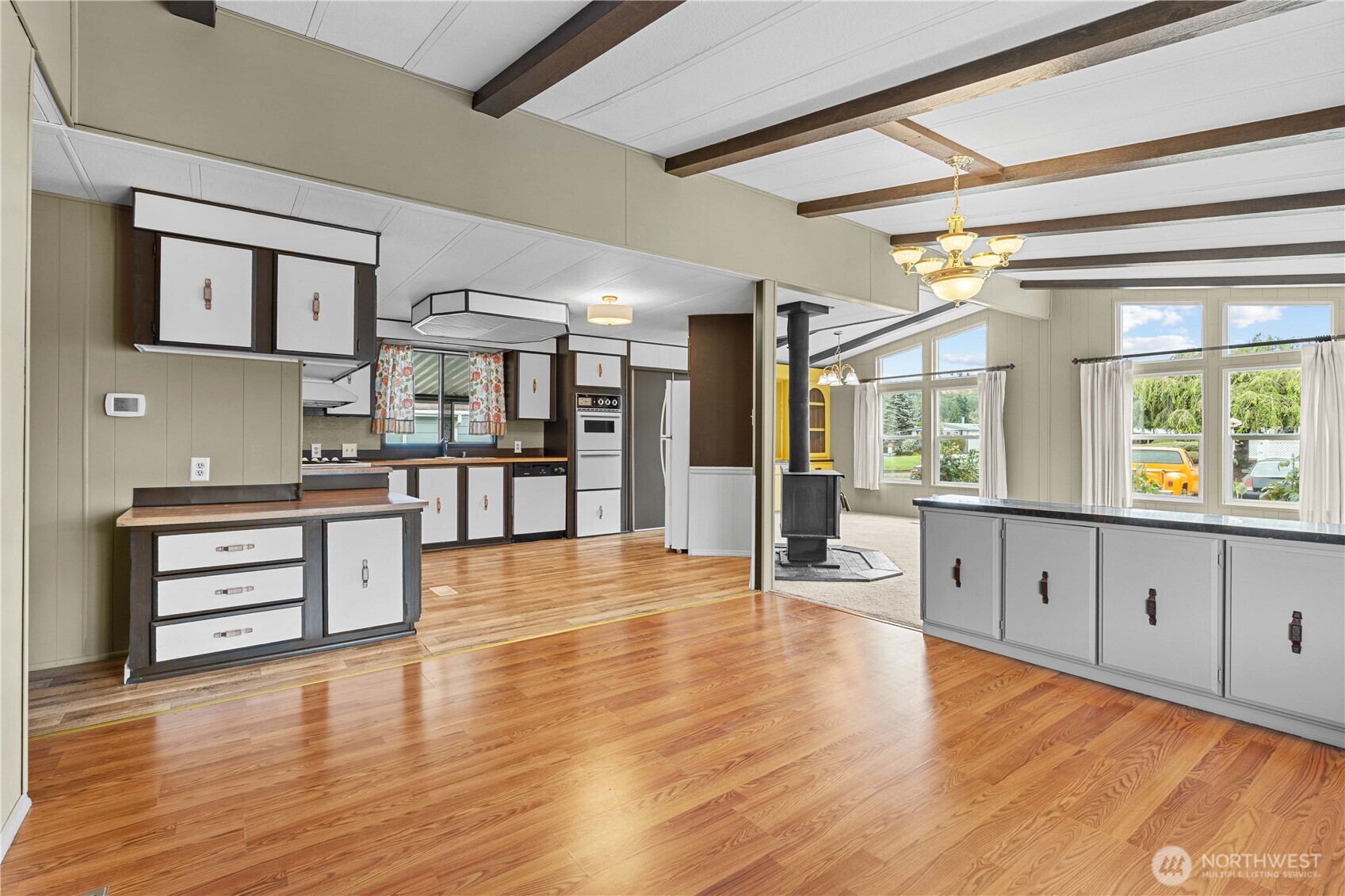 Another angle of the bright living space with kitchen and seating/living/dining area