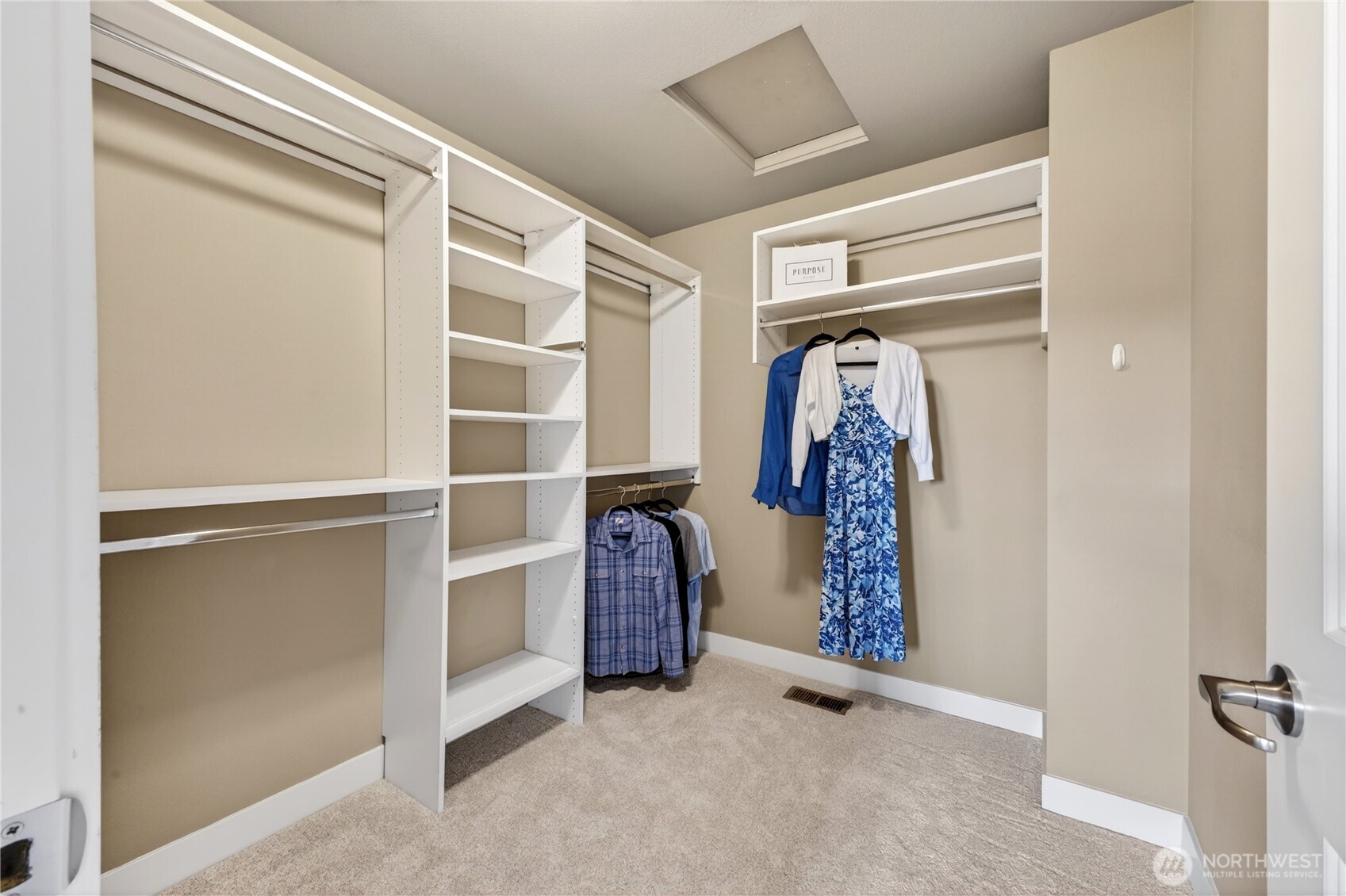 Spacious walk-in closet features a custom organization system designed for both function and style.