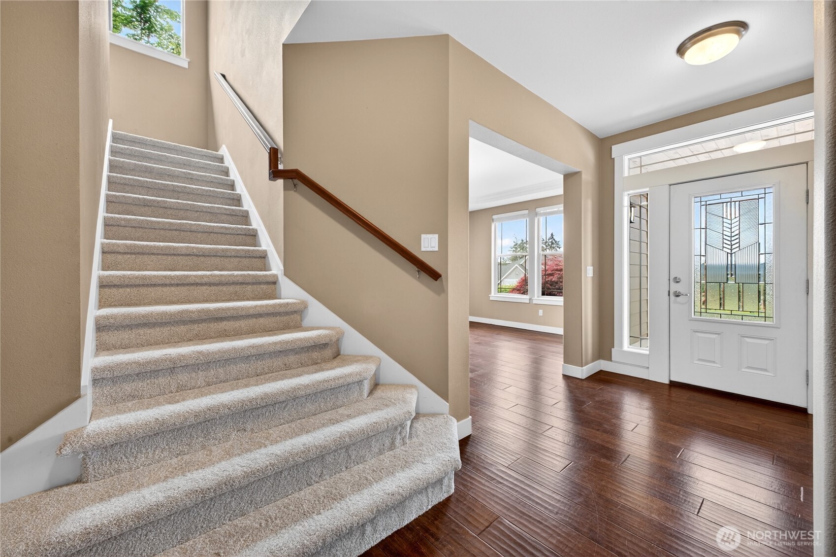 Additional highlights include new carpet, crisp white trim, energy-efficient solar panels, all appliances included, soaring ceilings, and beautifully wood-trimmed windows.