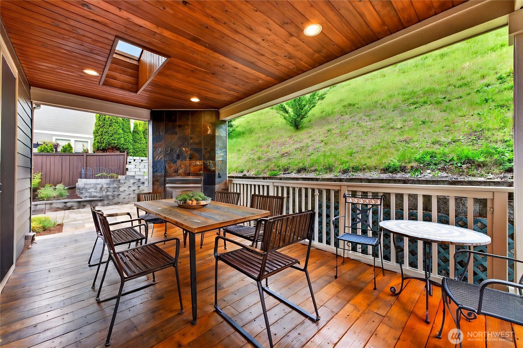 Private covered deck is an inviting outdoor retreat featuring a skylight, gas fireplace, and built-in lighting—perfect for relaxing evenings or year-round entertaining.