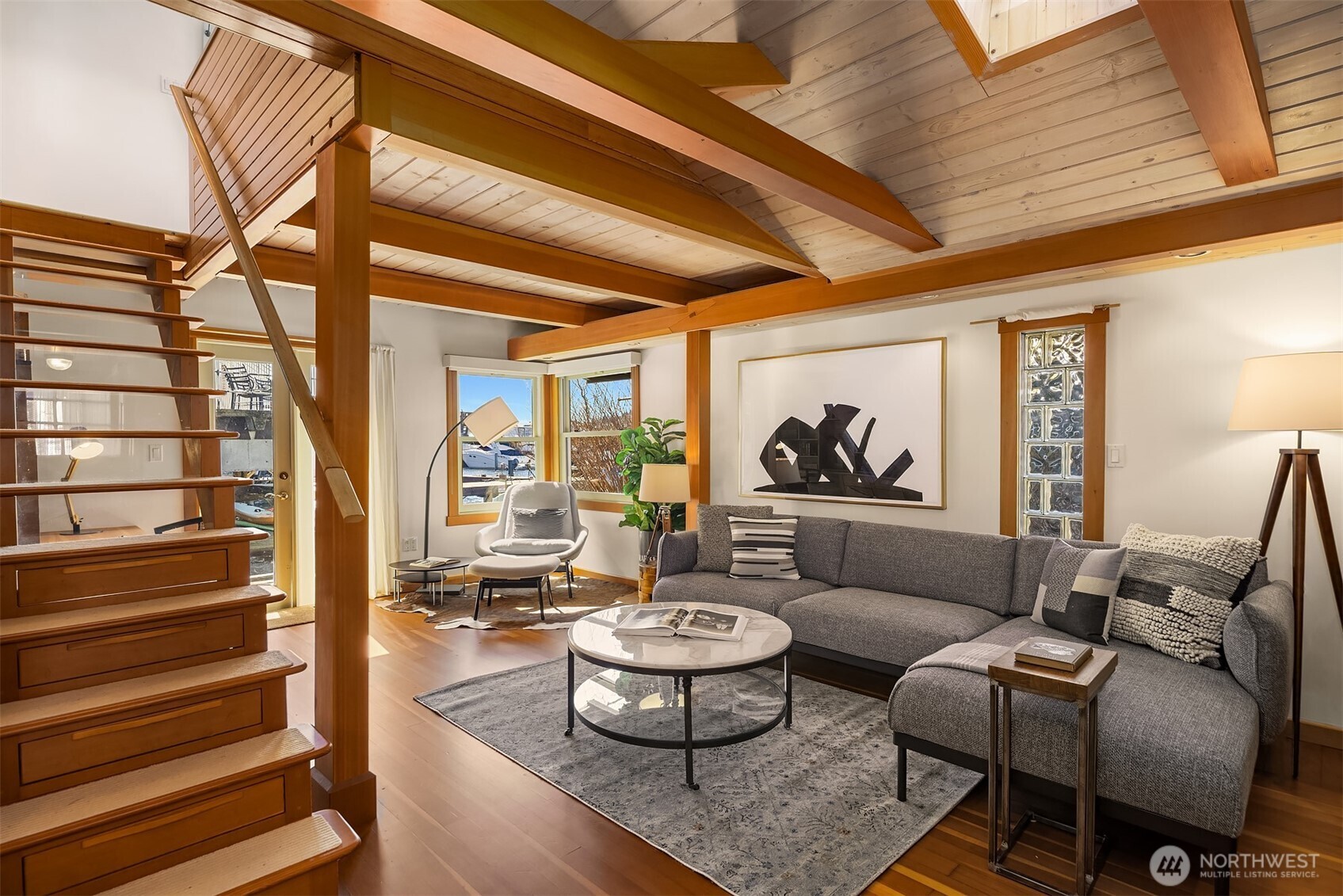 Dramatic vaulted ceilings with exposed Douglas fir beams, a skylight overhead, and a beautiful wood staircase make the living room the architectural heart of the home.