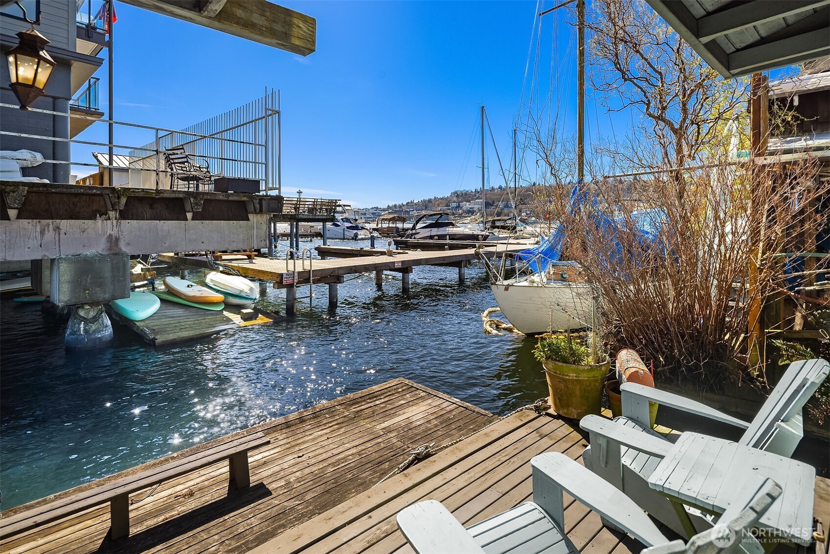 Step off the living room onto your private dock-level deck, where Adirondack chairs face the marina and Lake Union stretches out in front of you on a sunny Seattle afternoon.
