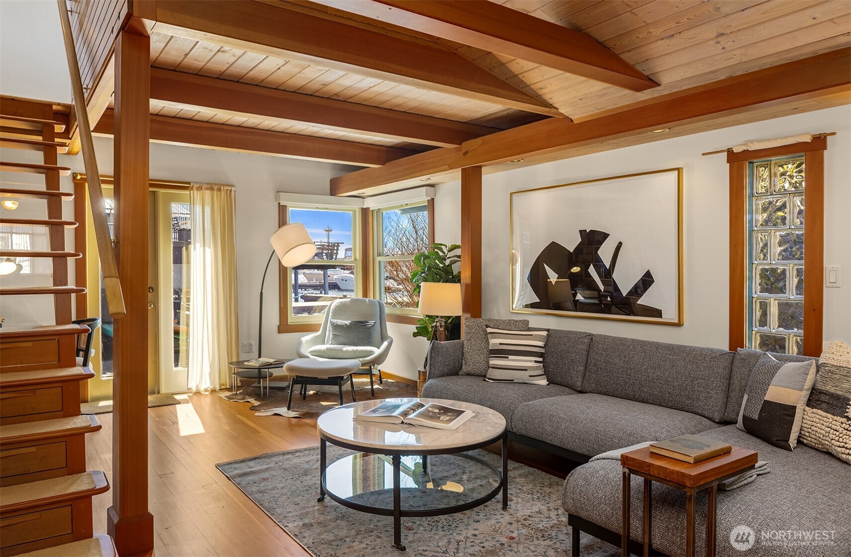 Rich hardwood floors, warm beamed ceilings, and water views through the windows give the living room a timeless, crafted quality that's rare in any home — let alone one that floats.