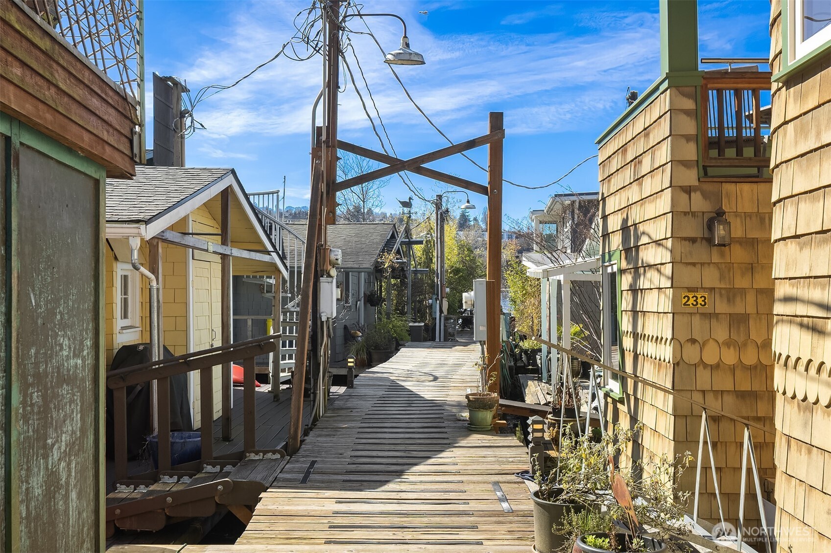 The dock through the moorage community, lined with neighboring homes and potted plants, captures the close-knit village character that makes the Willow dock feel like a world apart from the rest of the city.