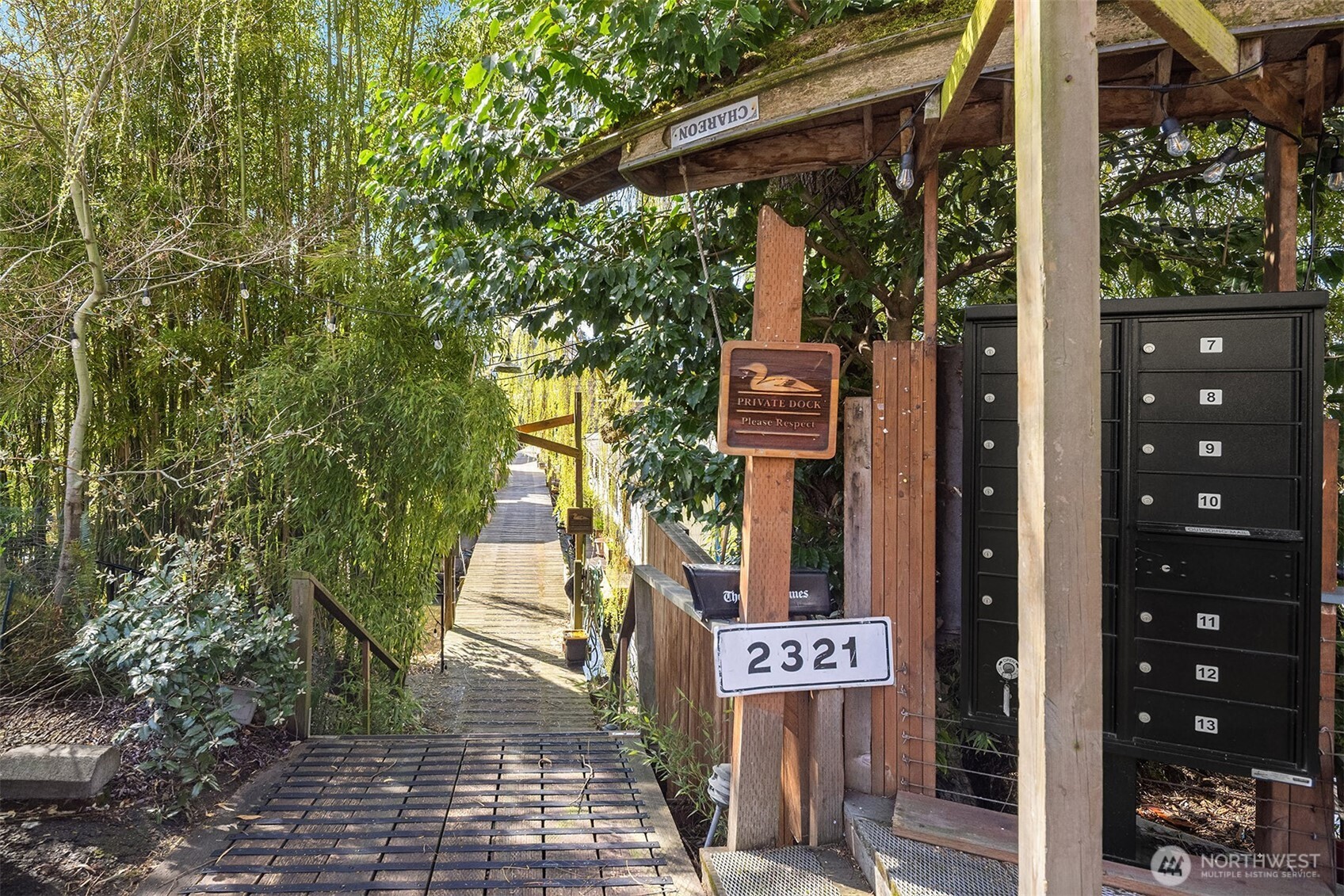 The moorage entrance at The Willow Dock sets the scene: a pergola, mature trees, and a row of mailboxes, covered by an upside down canoe, mark the beginning of something truly different from a standard Seattle address.