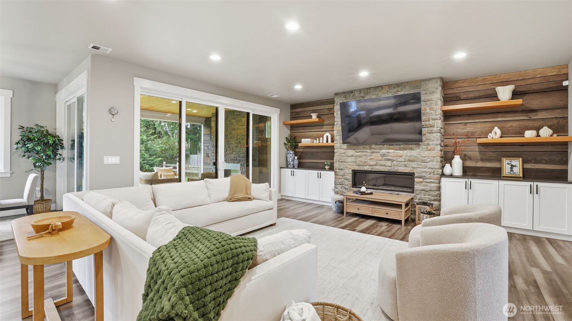 The living room showcases custom built-ins, gas fireplace, and sliders to a covered patio.