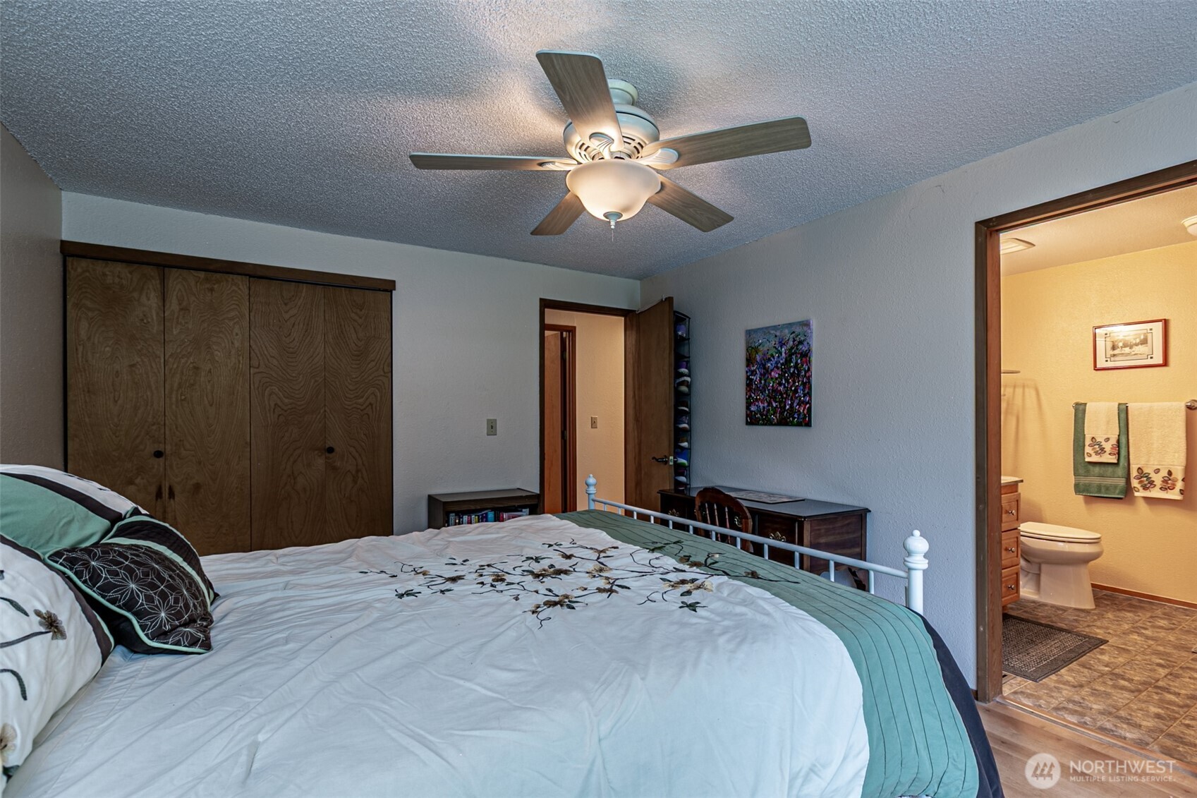 The primary suite with a ceiling fan, and a private bathroom.