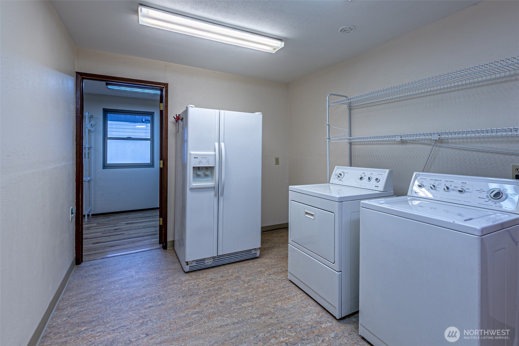 The spacious laundry room includes a second refrigerator