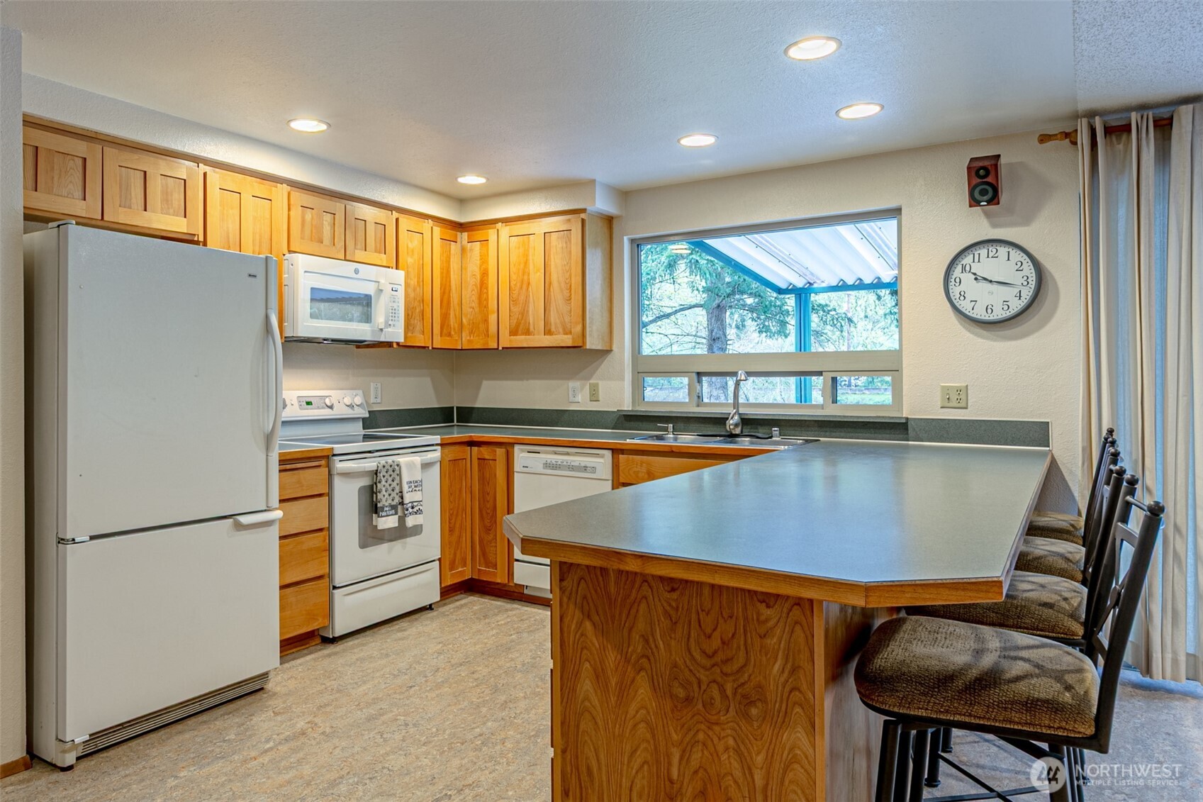 Kitchen with Easy Care Glass cooktop range. Loads of cupboards and countertops. The large kitchen window looks out on the waterfront and covered patio.