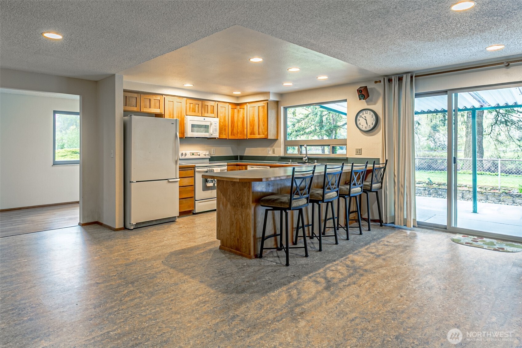 Here's the kitchen, dining room, patio door, covered patio, and back yard beside the waterfront.