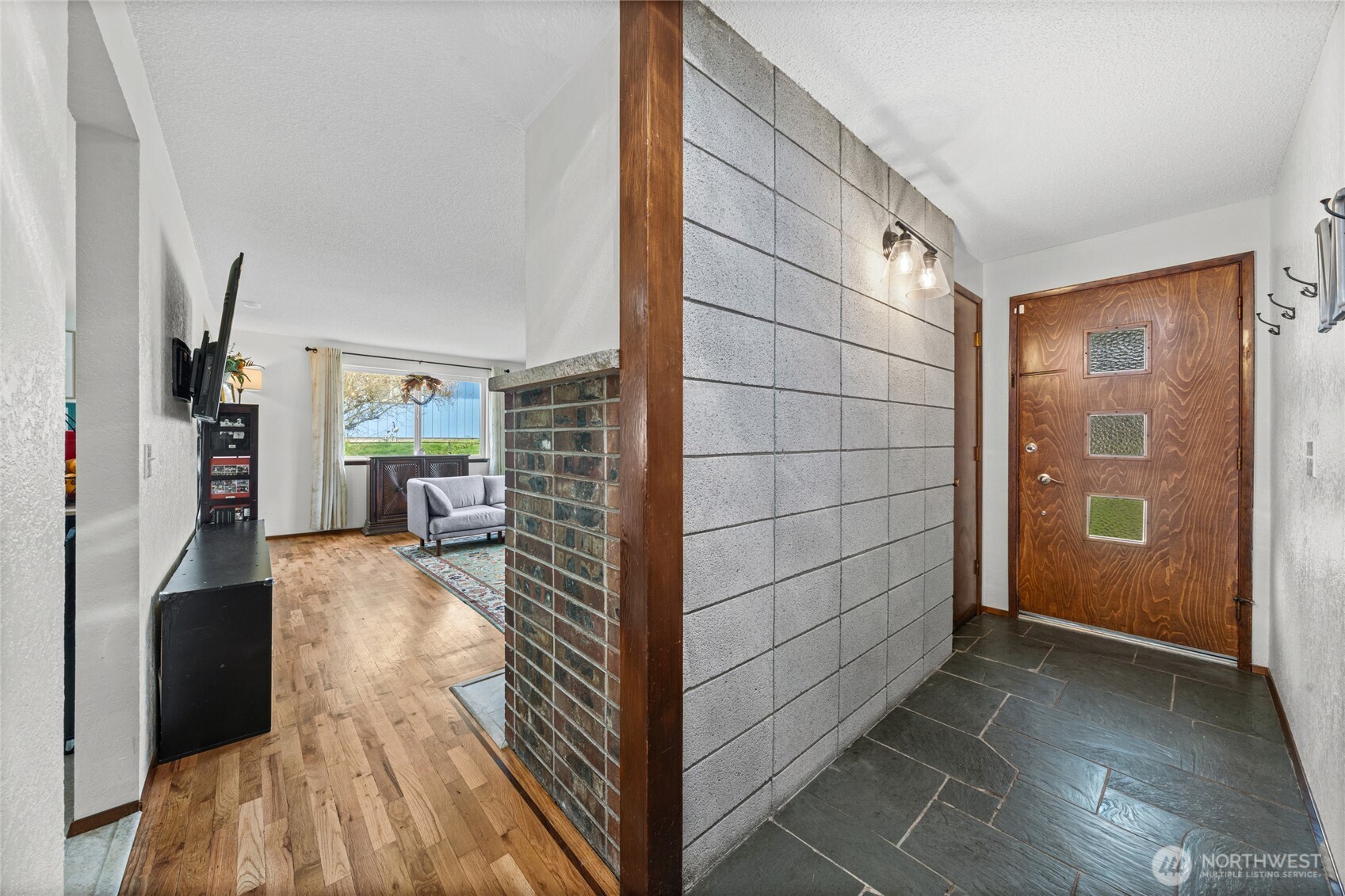 Foyer with beautiful stone tile and a coat closet to the left of front door.  The living room and kitchen are on this end of the home with the bedrooms and bathrooms at the opposite end.