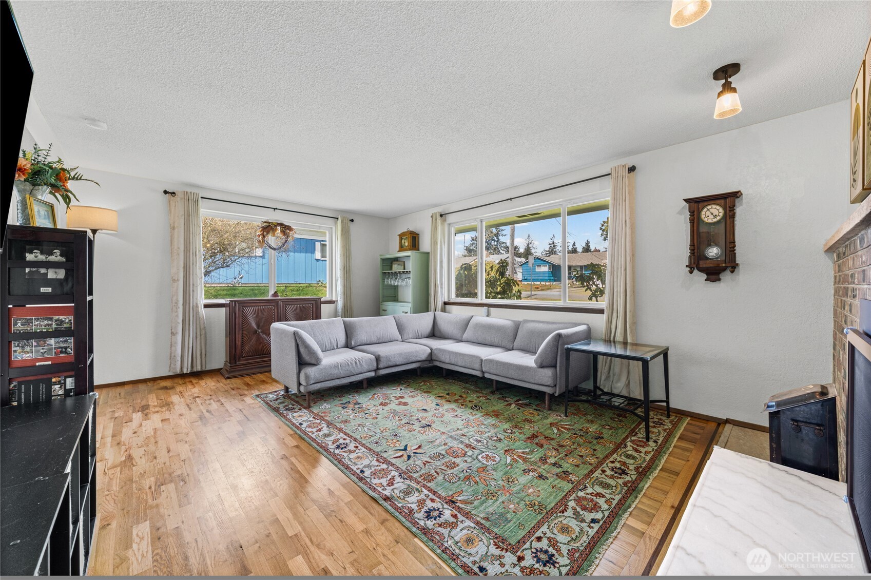 The spacious living room  get lots of natural light.  Notice the beautiful wood flooring.