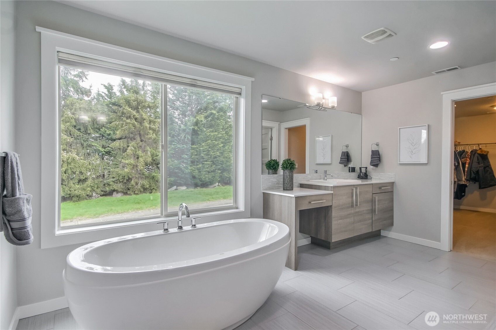 Primary bathroom ensuite with huge stand alone soaking tub, double vanities & tile accents in the shower.