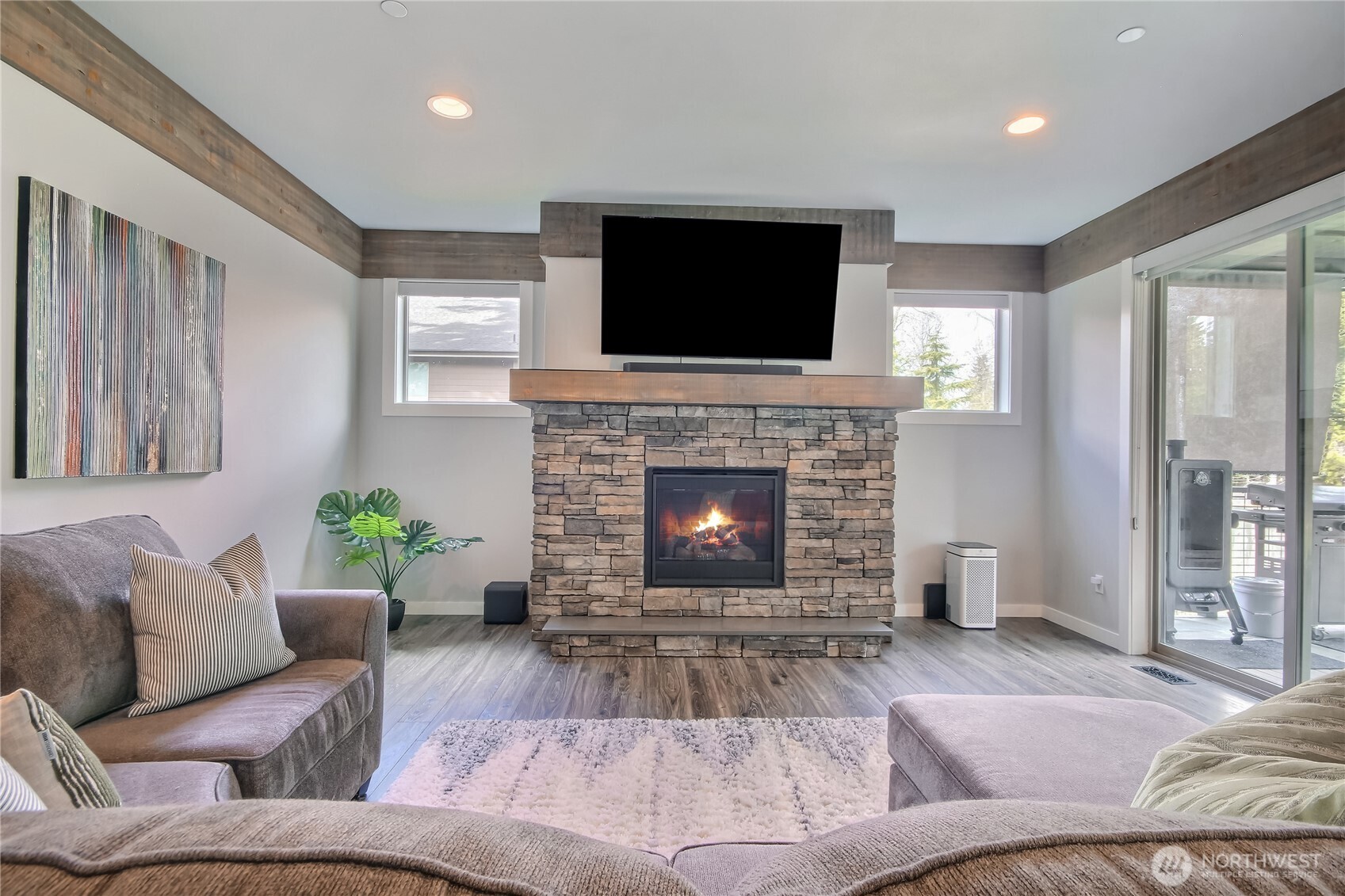 Living room w/ gas fireplace and floor to ceiling glass sliders that open to the covered deck w/ gas fireplace.