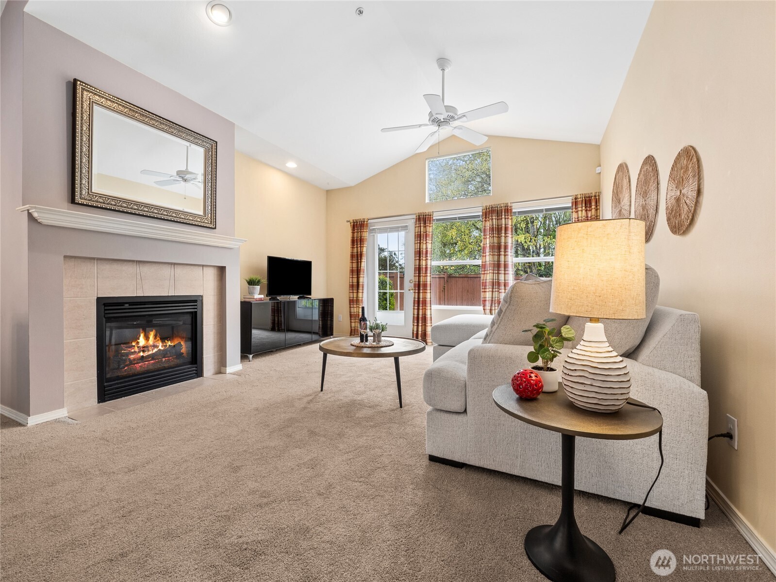 The living room is warm and inviting, with vaulted ceilings and large windows that bring in great natural light and views of the greenery outside. The cozy gas fireplace adds a nice focal point, while the open layout makes it an easy space to relax or entertain.