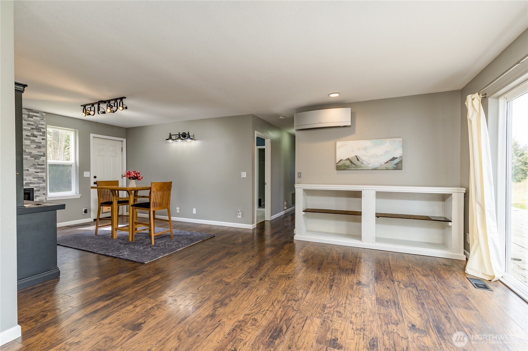 Versatile flex space adjacent to the kitchen, featuring a cozy sitting area with a fireplace and mini-bar—perfect for entertaining with seamless access to the deck
