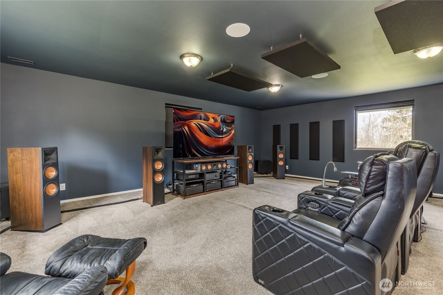 The Crown Jewel: A professionally sound-proofed, custom-installed home theater system that must be heard to be believed. Enjoy the cinematic excellence featuring a top-of-the-line 83" Sony OLED UHD TV and a massive 17-speaker Klipsch & REL surround system.