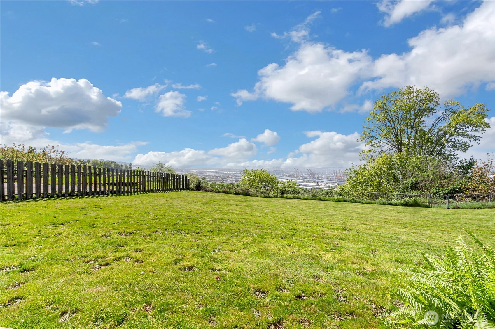 Vacant attached Lot starts flat and drops over the side, can be cleared for maximum build site or keep untouched for Privacy