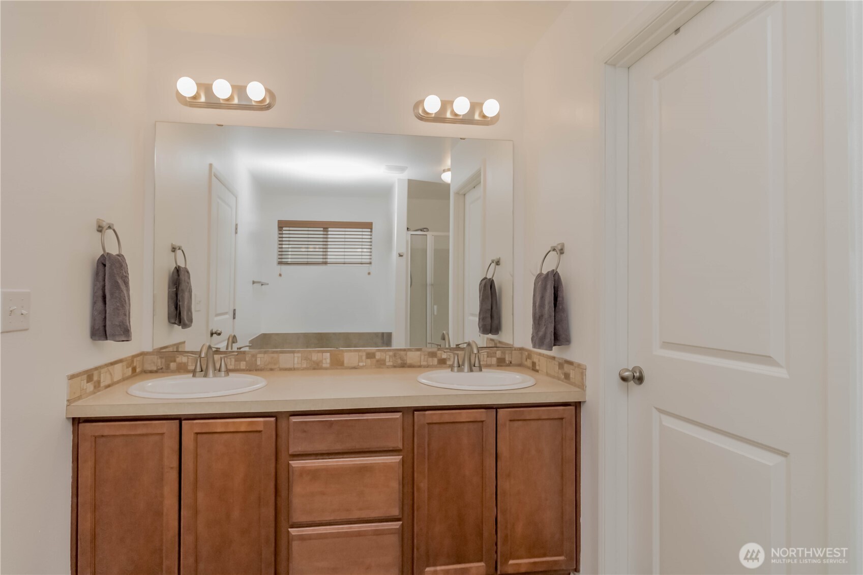 Great primary bathroom space with new sinks, hardware and lighting