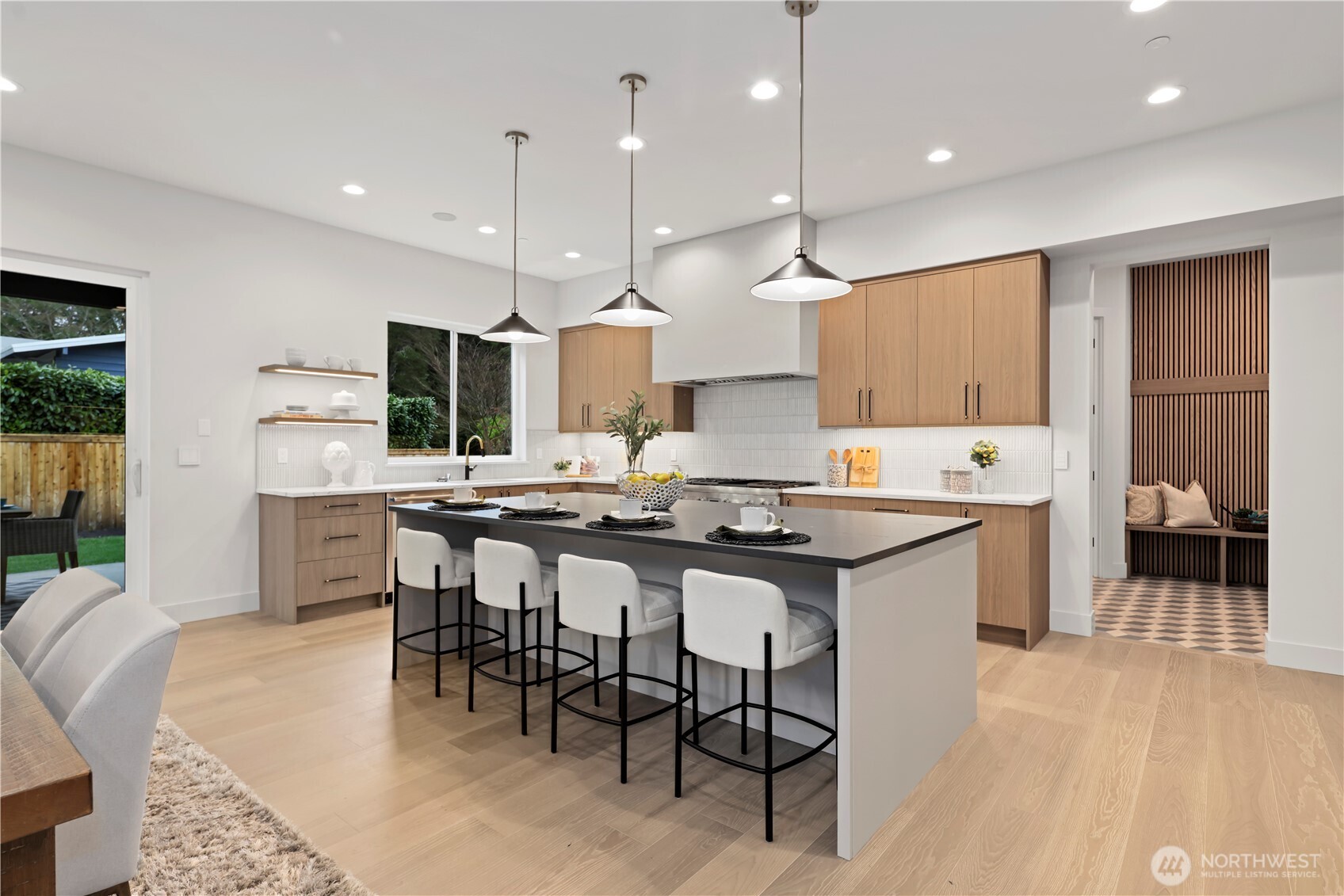 Butler’s pantry with beverage fridge, quartz countertop, statement backsplash detail including under cabinet lighting.