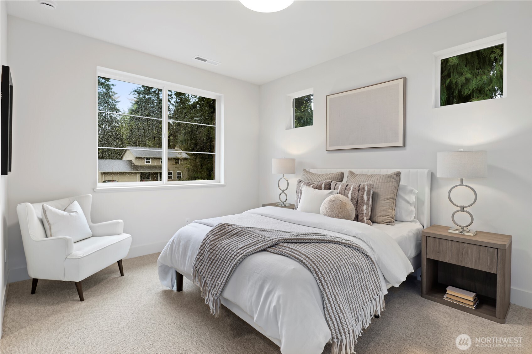Bright south-facing upper bedroom with space for a queen bed and a desk or sitting area. Walk-in closet includes a high window for added light.