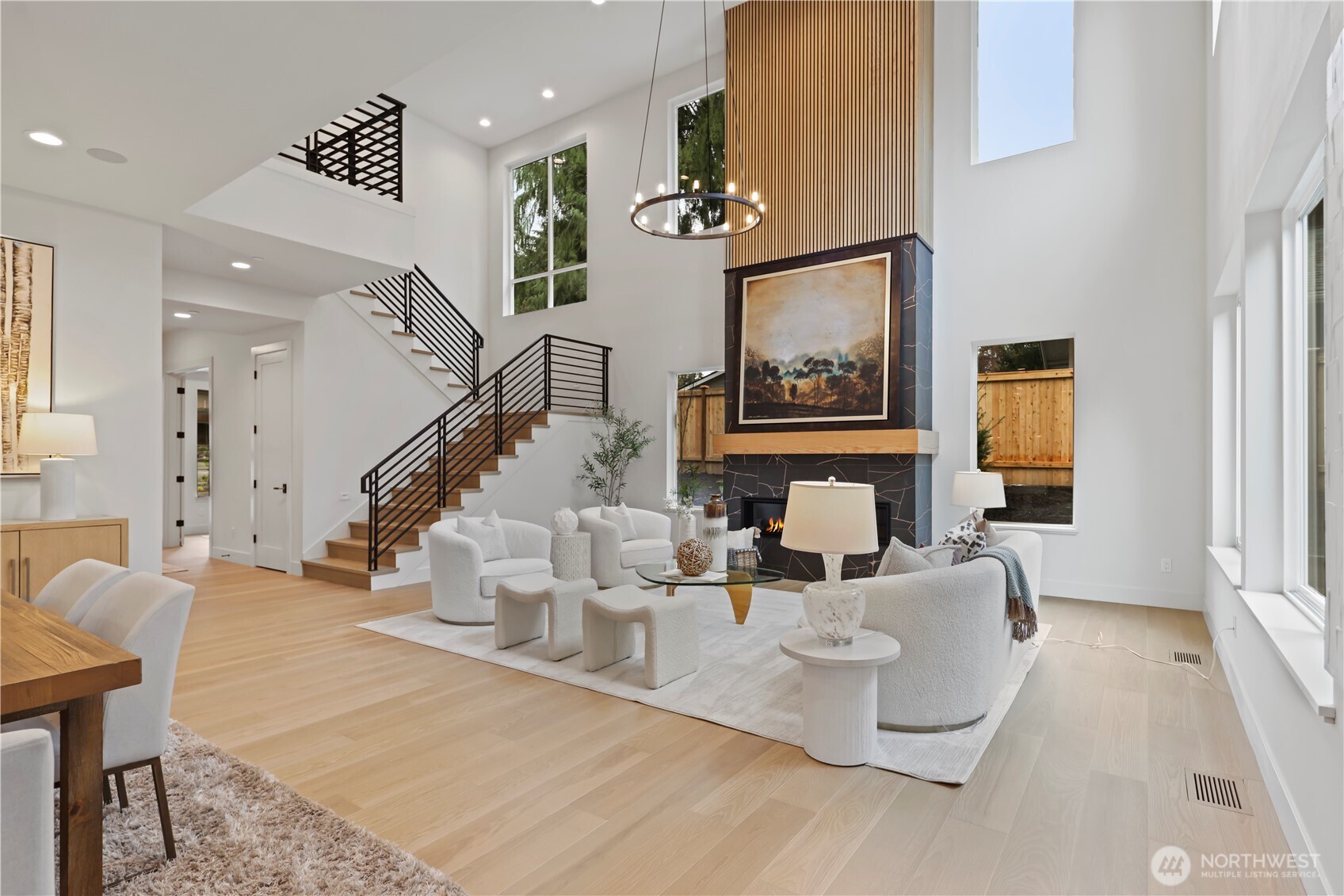 Dramatic two-story fireplace with large-format porcelain tiles, gold veining, and vertical slat panel accents, designed as a statement focal wall.