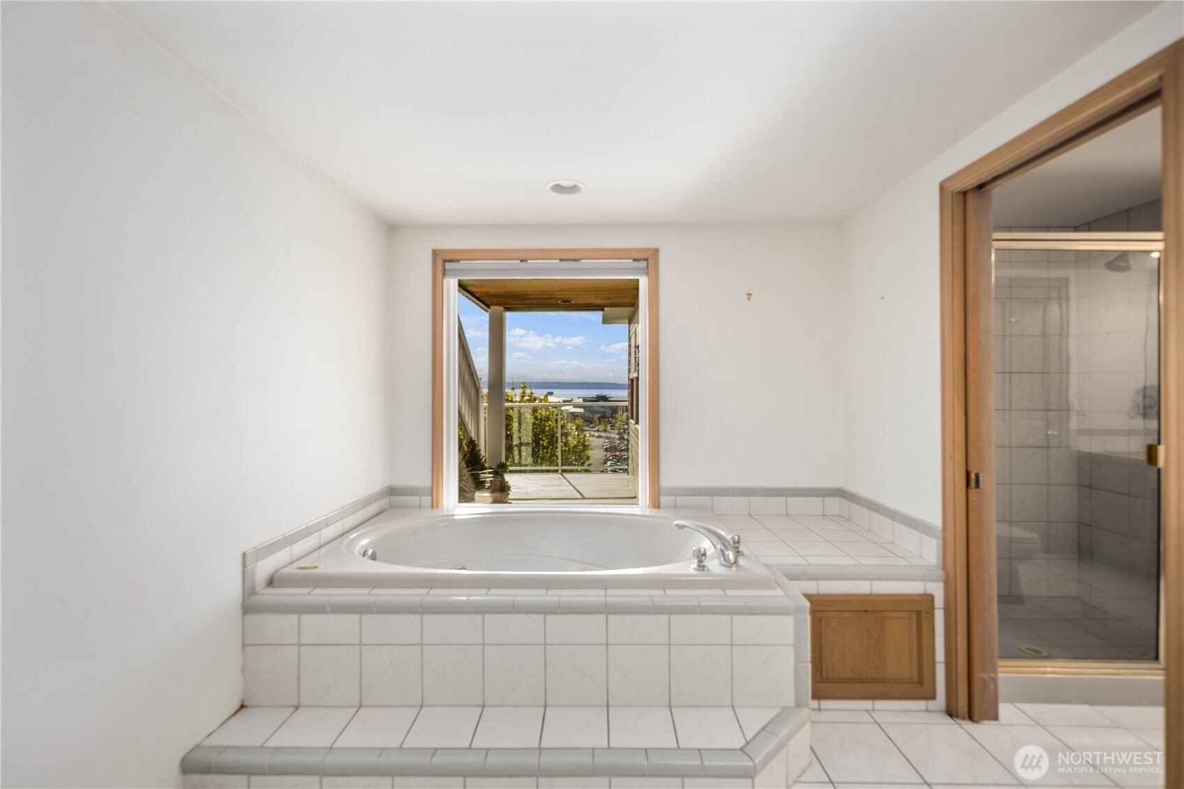 primary bedroom Jacuzzi tub with views and privacy window