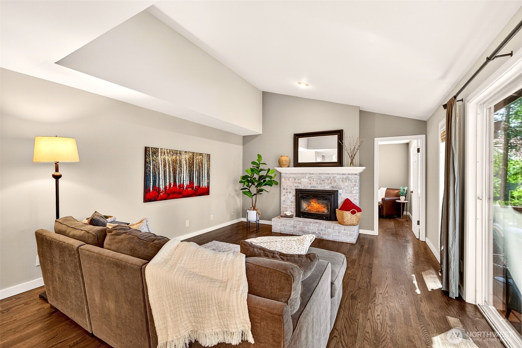 The vaulted family room is anchored by a classic brick fireplace and opens directly to the back deck — a naturally bright, airy gathering space that transitions effortlessly between cozy evenings in and outdoor entertaining.