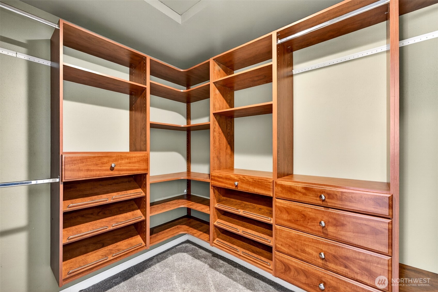 The primary suite's walk-in closet delivers a boutique-level storage experience — with rich wood built-ins, adjustable shelving, pull-out shoe racks, and generous drawer space thoughtfully designed for two.