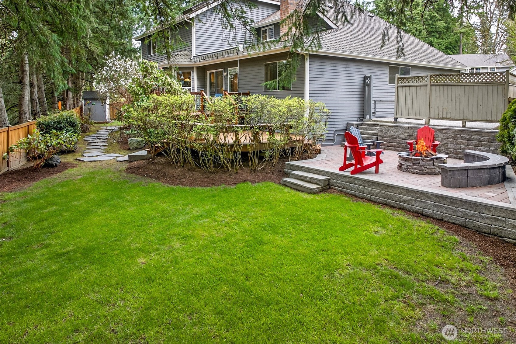 The fully fenced backyard offers a rare combination of space, privacy, and outdoor livability — with a lush lawn, paver patio, fire pit gathering area, and a multi-level deck that elevates outdoor living on English Hill.