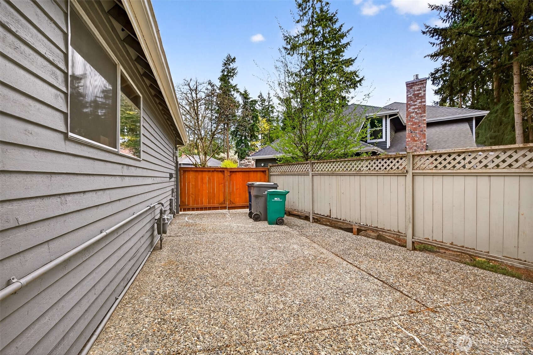 A gated side yard passage provides secure, convenient access around the home — a practical feature for outdoor storage, pet containment, or utility access, all neatly tucked behind the fence line.