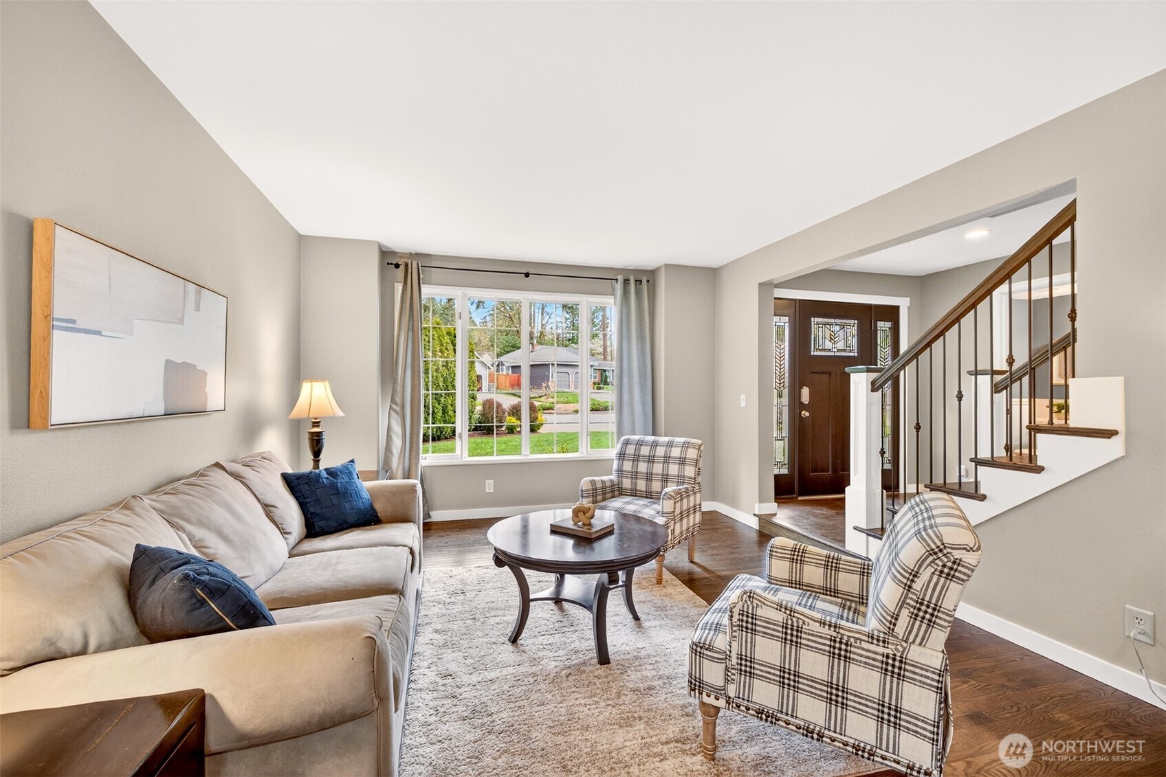 Oversized windows flood the living room with natural light while framing a peaceful, leafy outlook — a bright, welcoming retreat just minutes from Microsoft, Google, and major Eastside tech corridors.