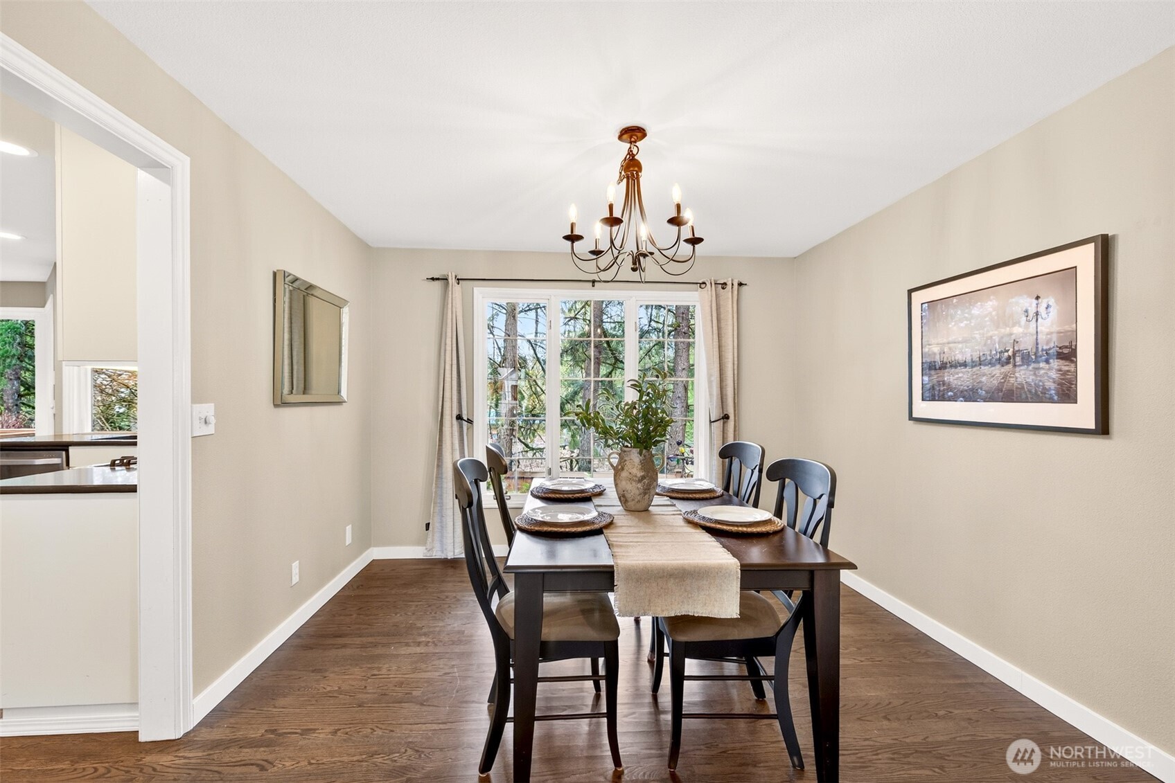 The formal dining room is perfectly scaled for gatherings, with garden views through a large picture window and an elegant chandelier overhead — a room that makes every meal feel like an occasion.
