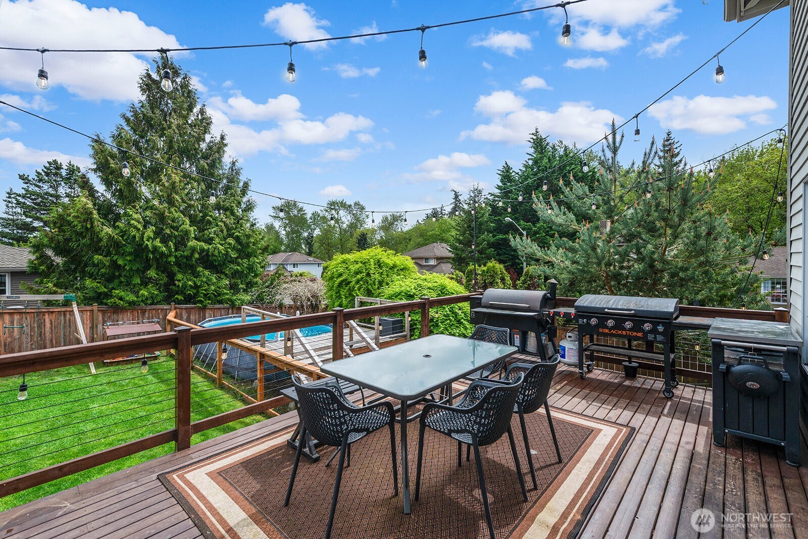 Deck over looks above ground pool and play area in teh back.
