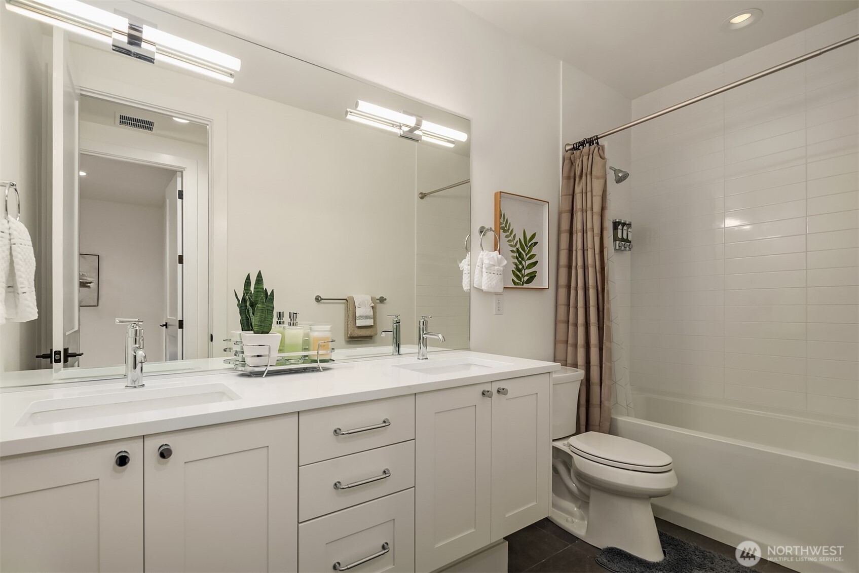 This large full bath offers a double sink vanity full of storge space with a smooth top vanity giving room for everyone. The modern lighting is mounted in the mirror for a flattering look. The tub and shower are finished off with classic subway tile for a timeless look.