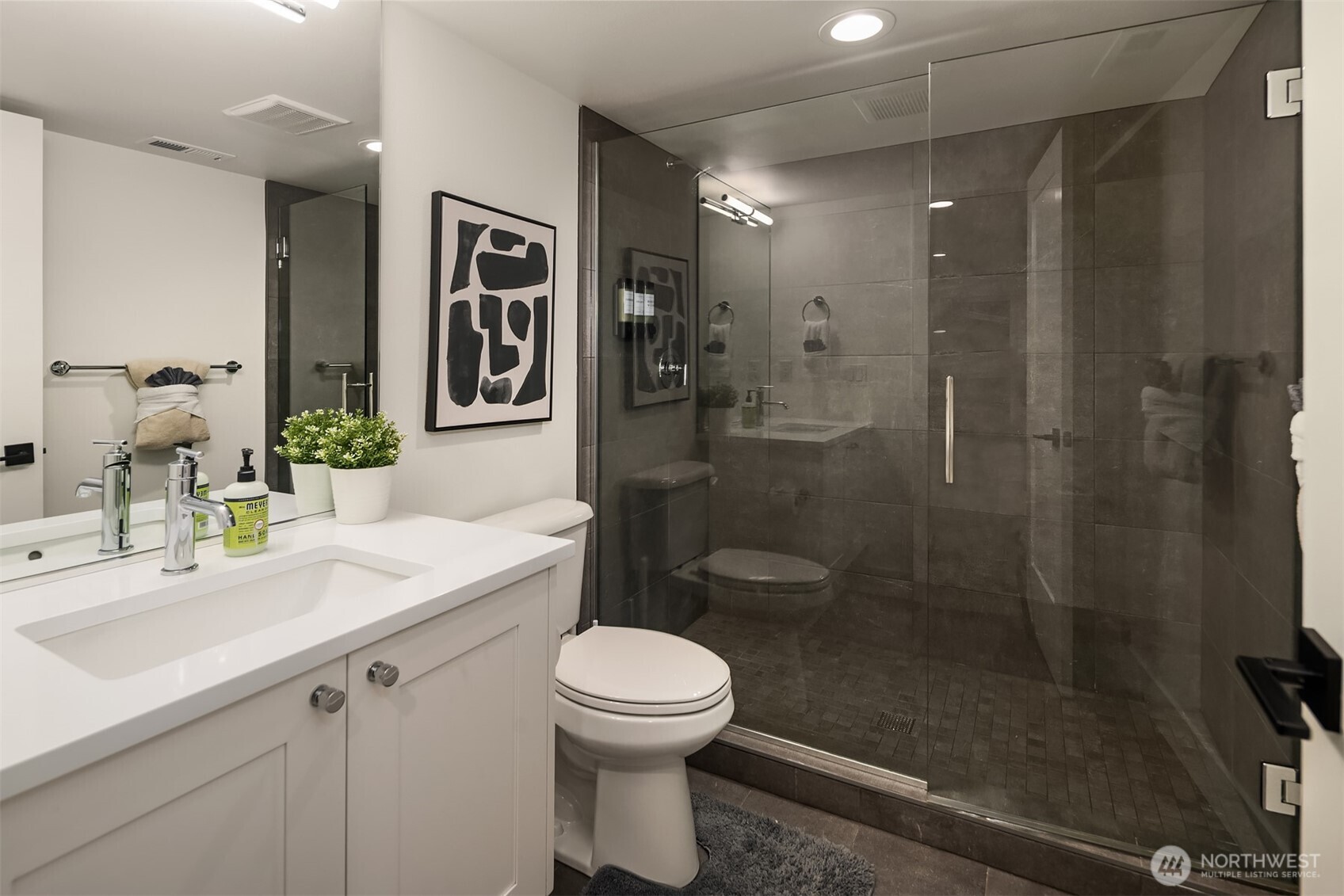 A well-dressed three-quarter bath serves the lower level with an impressive oversized walk-in shower, seamless glass door and handsome custom tile.
