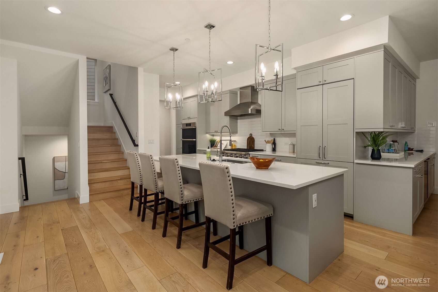 In the heart of the home, a large center island with lovely pendant lighting is designed to be both beautiful and functional, a natural gathering place for family and friends to hang out.