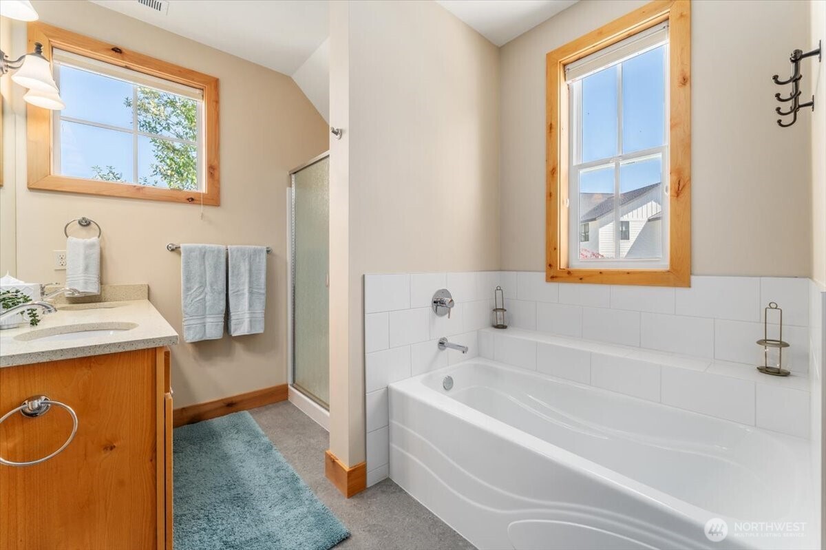 View 2 of upper level Primary Bedroom full bathroom with quartz countertops and separate bathtub.