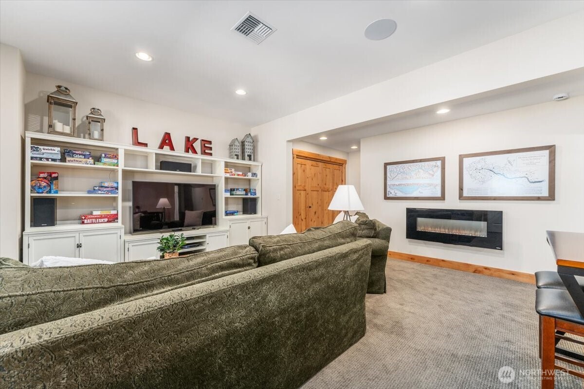 View 2 of lower level bonus/media room with electric fireplace.