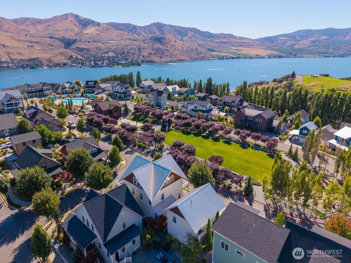 Aerial view of The Lookout's Hilltop Park with grassy area, playground, pickleball court, clubhouse, pool and hot tub.