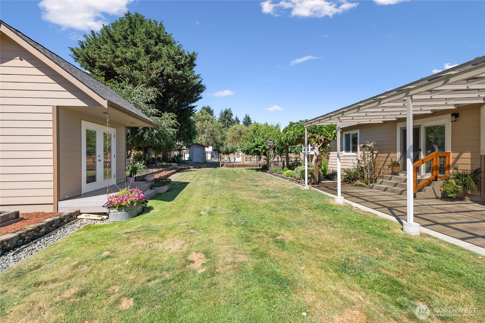 Back yard off of the kitchen- great for entertaining.   An extruded aluminum patio cover blocks approximately 70% of UVA and UVB rays, creating a more comfortable outdoor living space. Creative Cottage seen to the left.