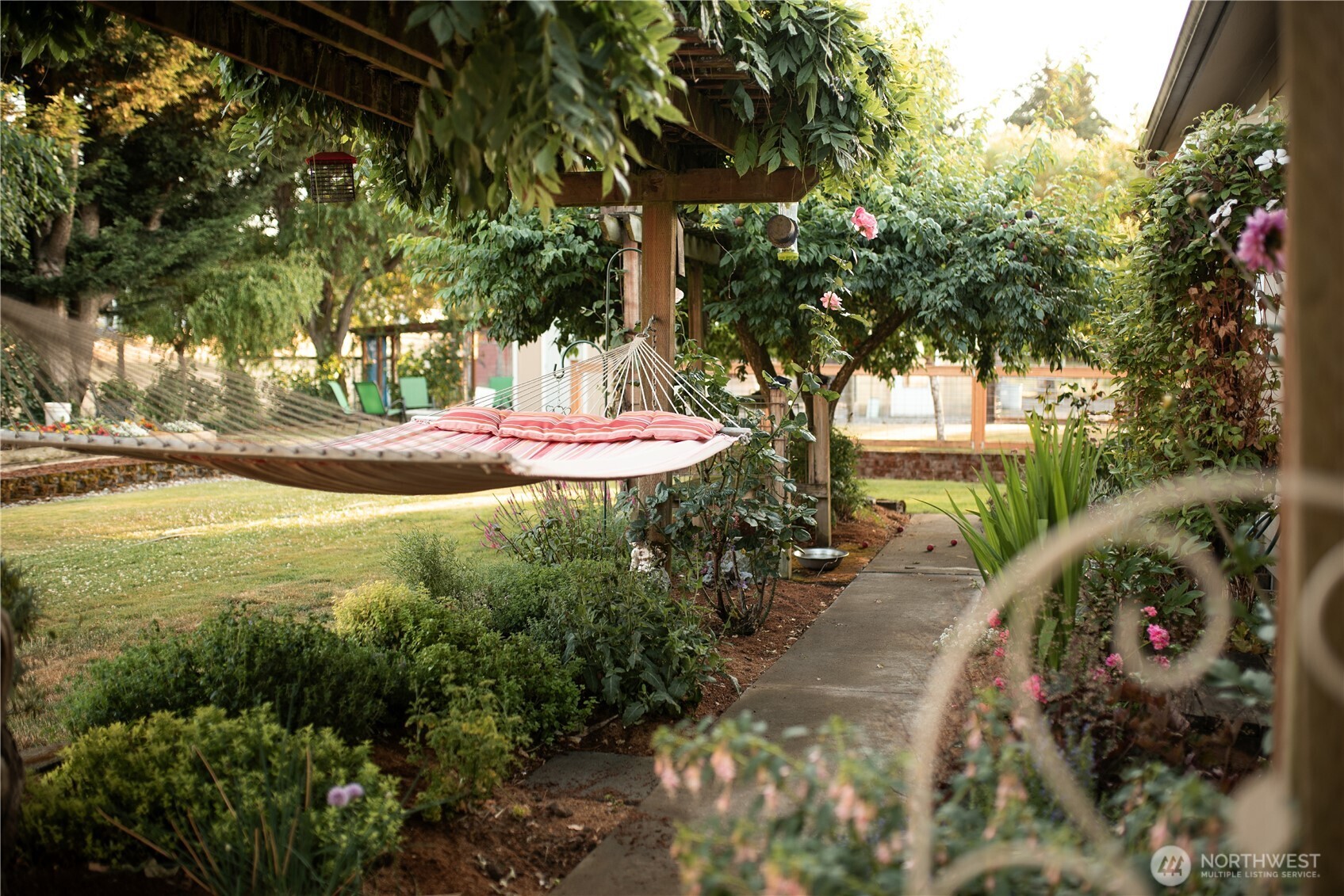 The landscape includes a culinary herb garden, white table grapes on an arbor, and a productive berry patch with raspberries, strawberries, and blueberries. An established orchard features multiple apple varieties, Italian prunes, Asian plum, pear, cherry, and wild field apples. Raised garden beds sit within a low-maintenance English-style garden designed to support pollinators, alongside a lavender garden with English, Spanish, and French varieties....