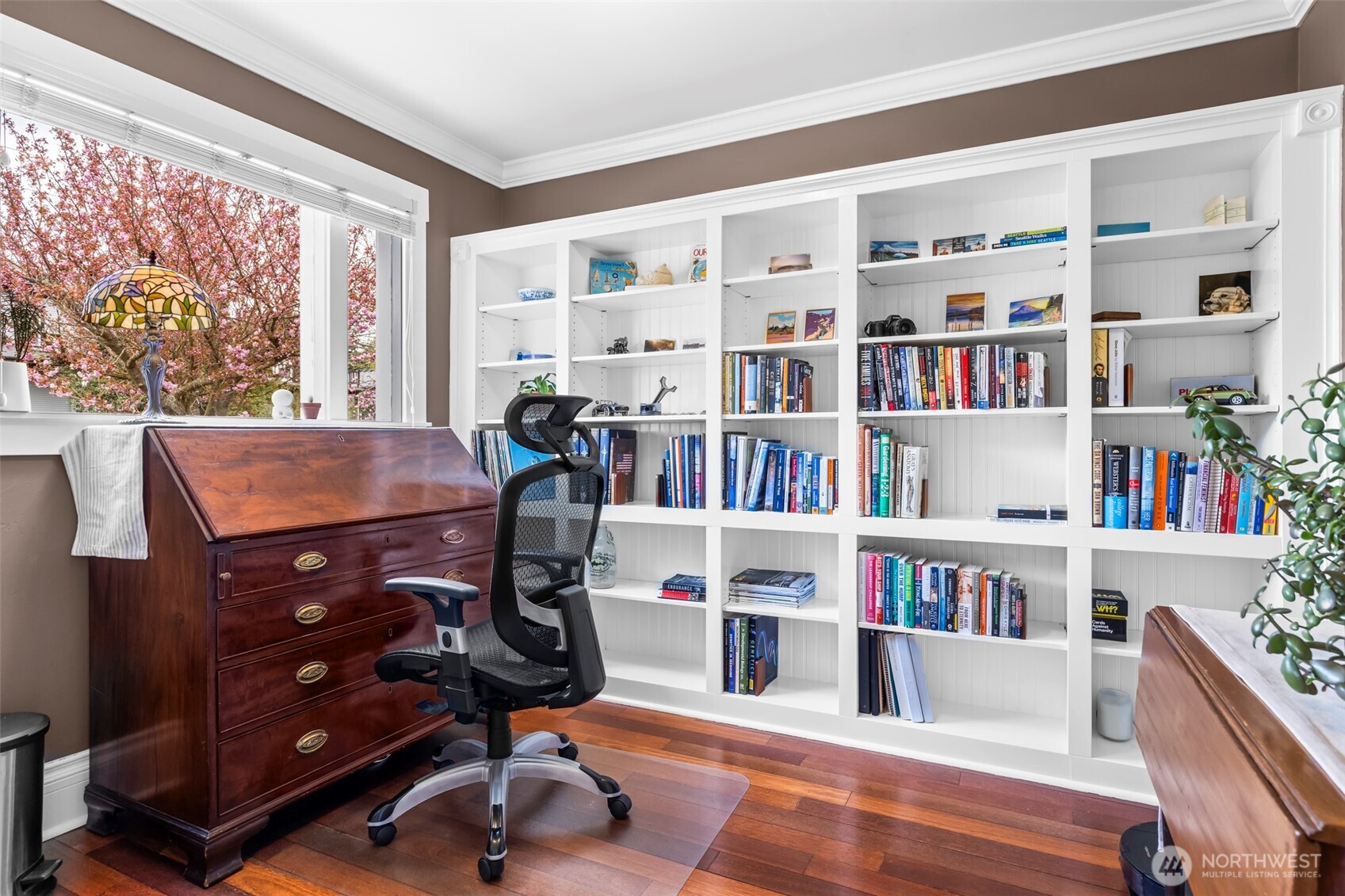 Front office w/ custom built-in bookshelves, overlooking the street.