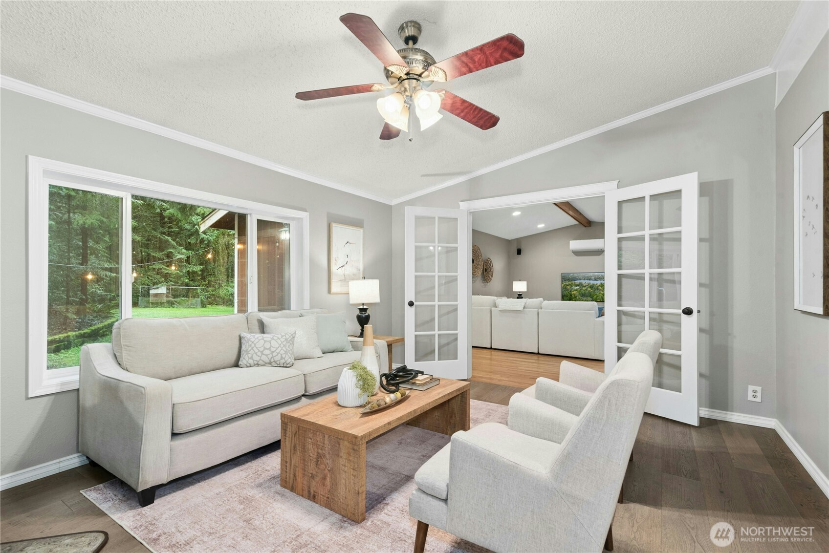 Formal sitting area with ceiling fan and newer LVP flooring. Featuring French doors to the Family Room.