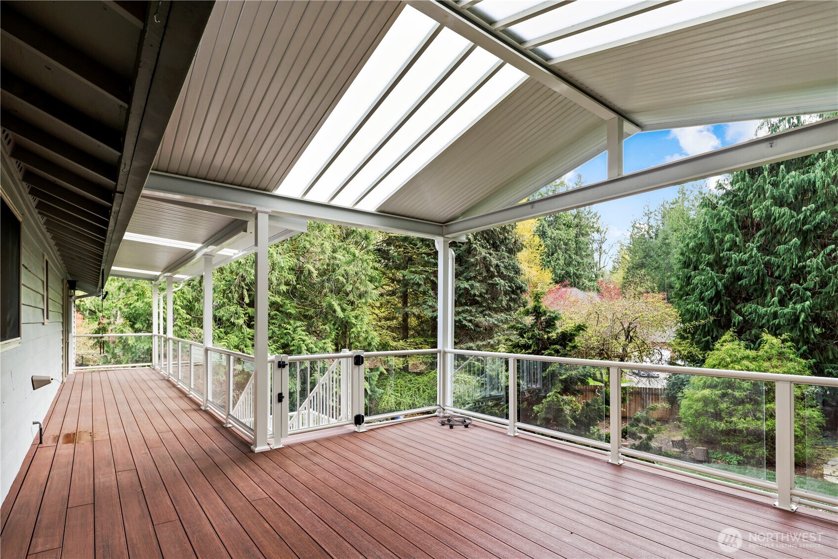 Fully covered deck stretches to the primary bedroom, has stairs (w/ gate) to the lower level & backyard space